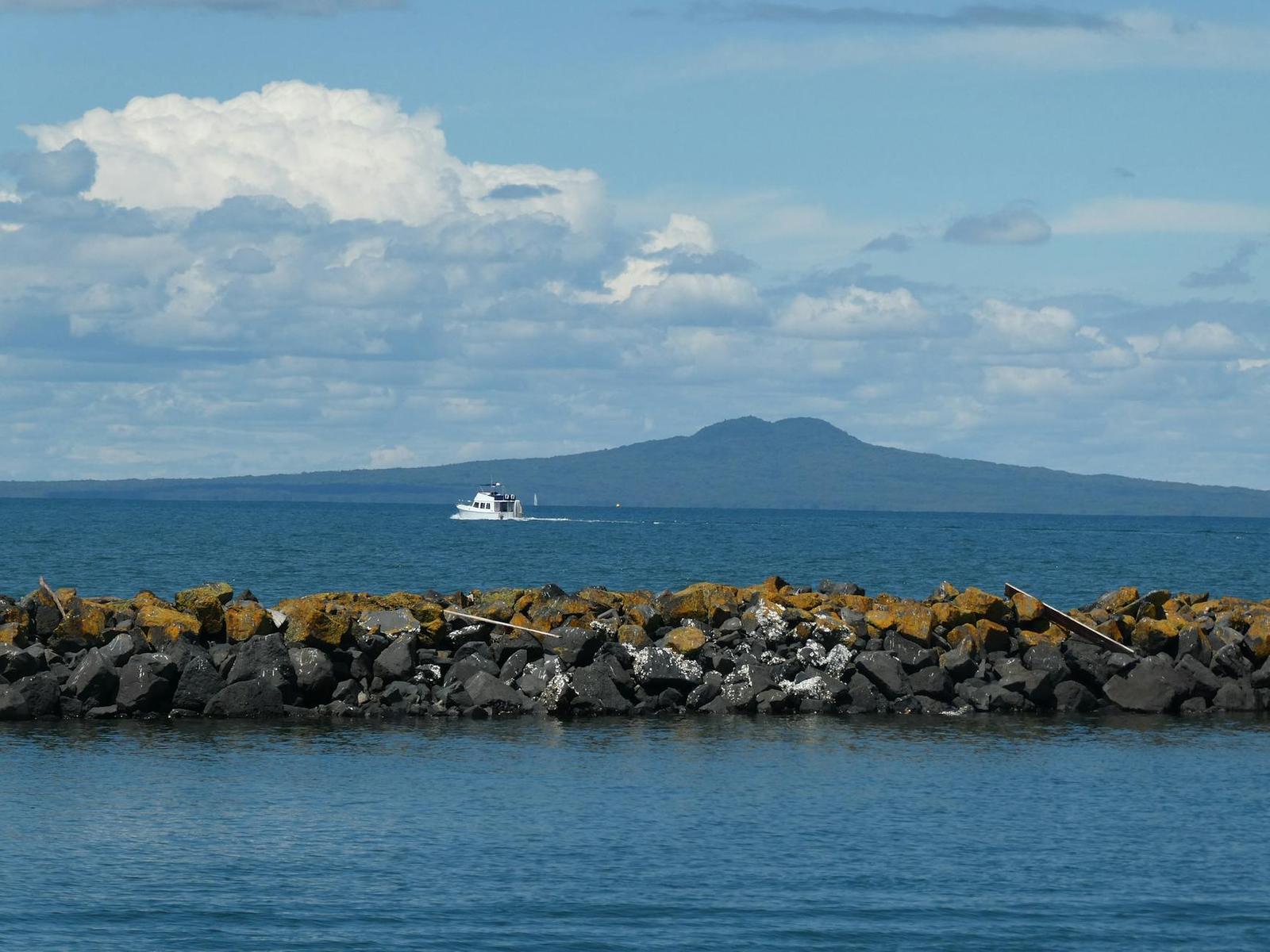Boat cruising near Rangitoto Island volcanic cone on Auckland's Hauraki Gulf