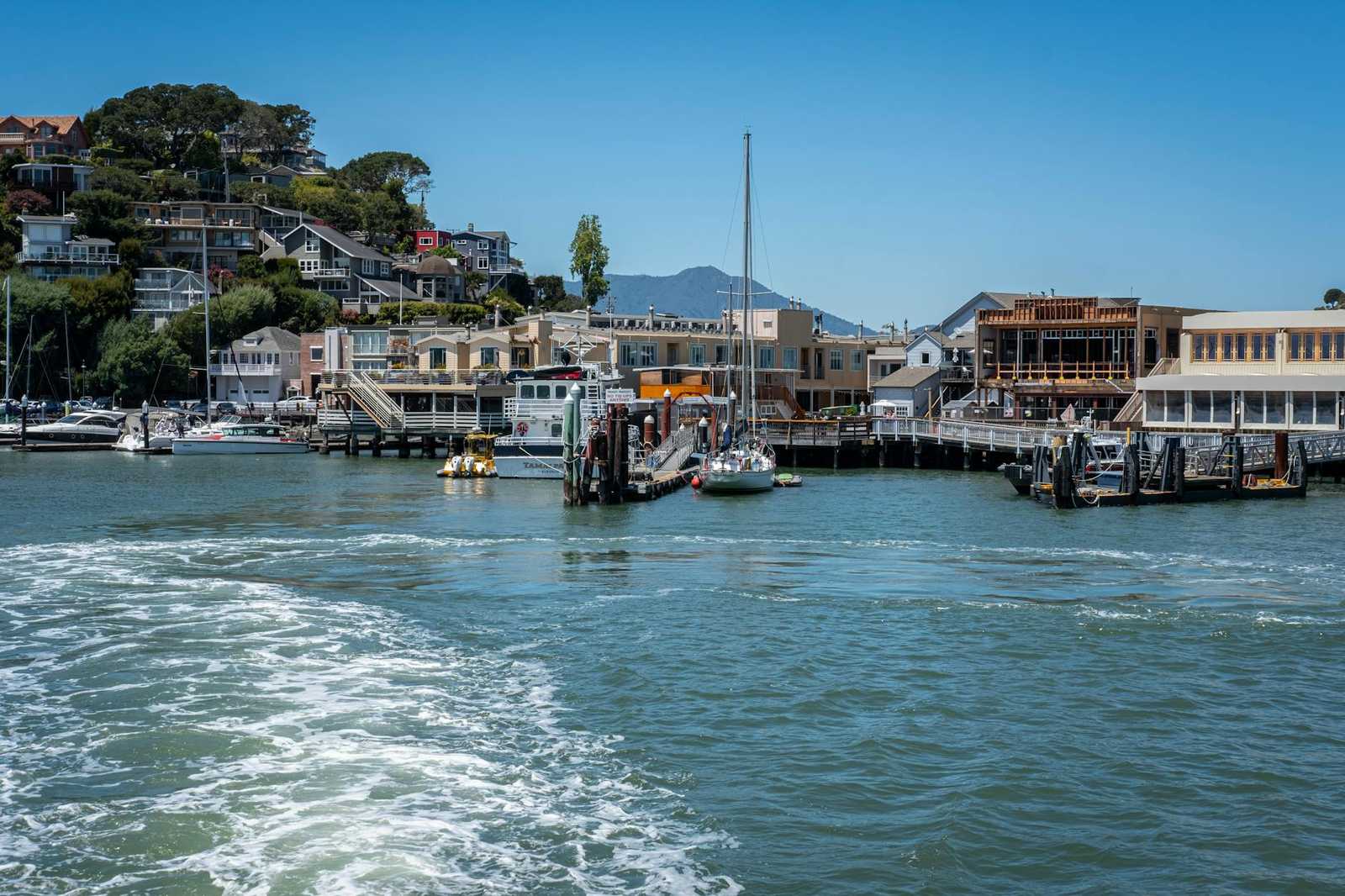 Ferry arriving at a waterfront village similar to Devonport Auckland