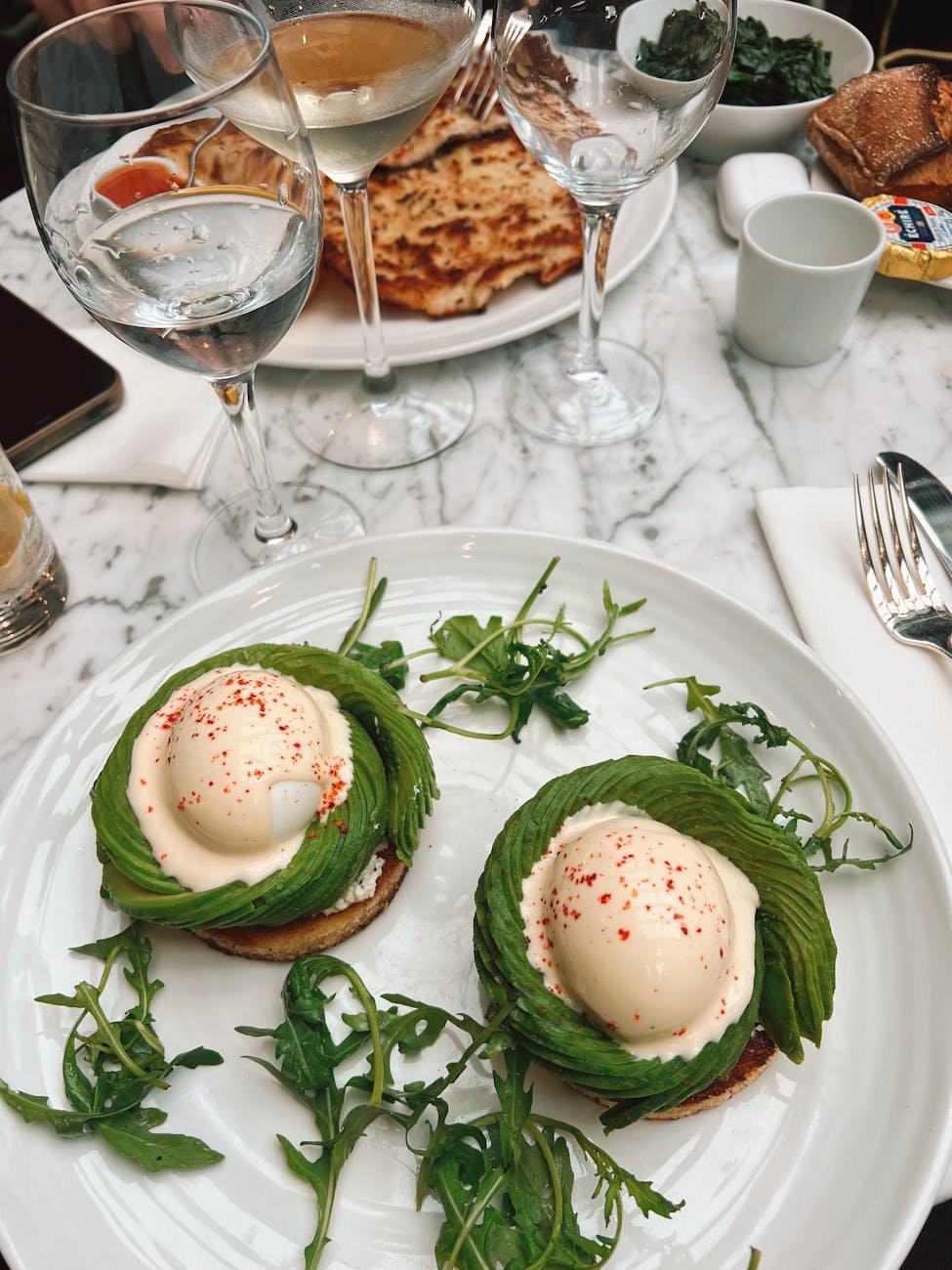 Brunch plate with eggs benedict and avocado toast at a cafe