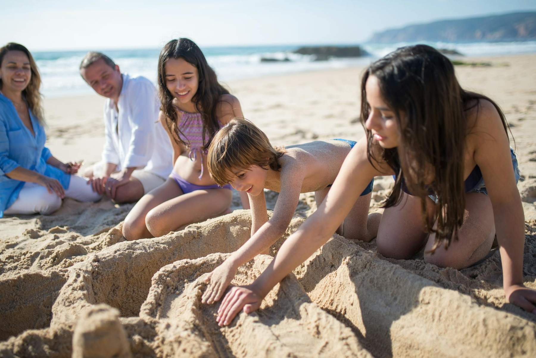 Kids building sandcastles and playing at an Auckland beach