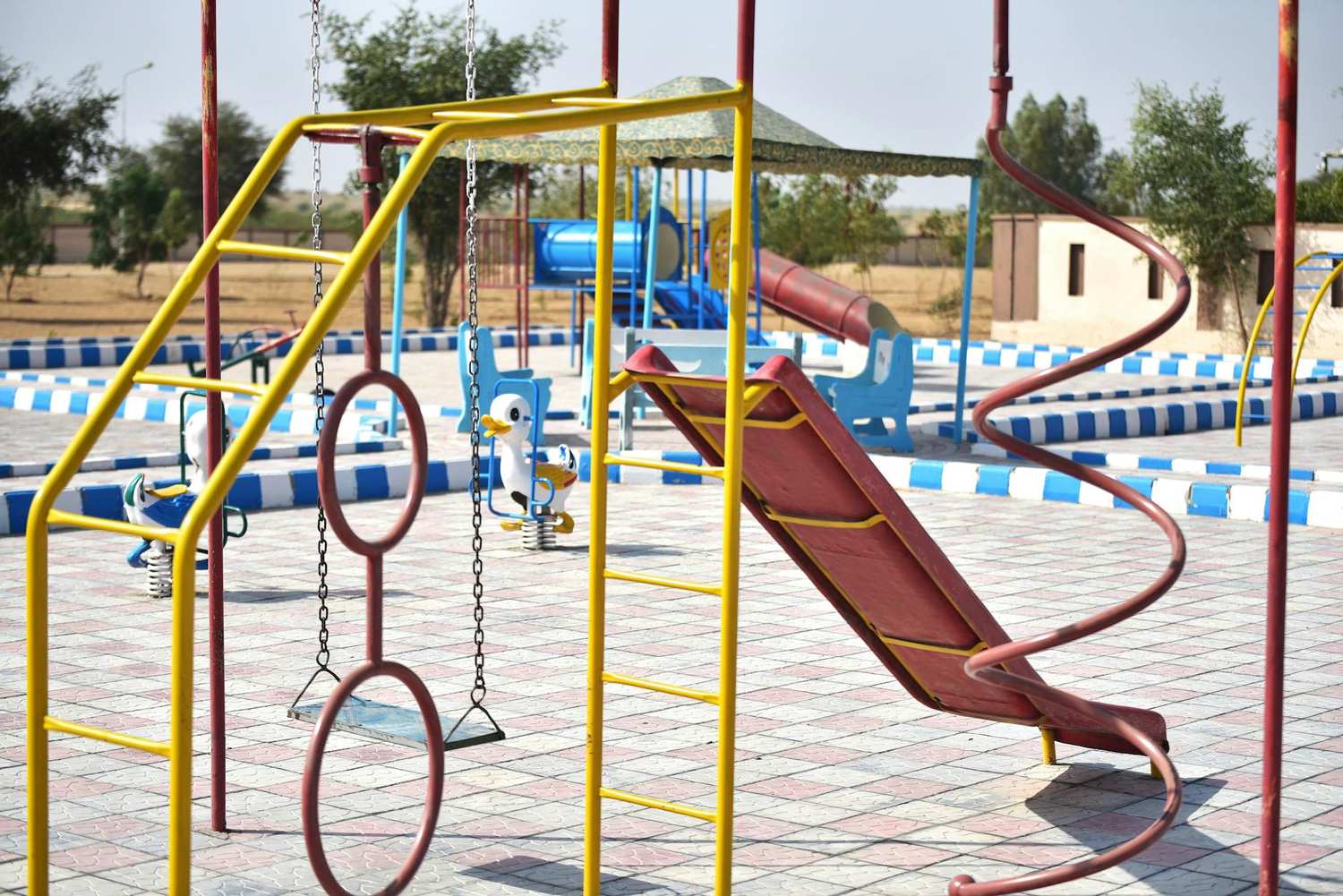 Children climbing and swinging on park playground equipment