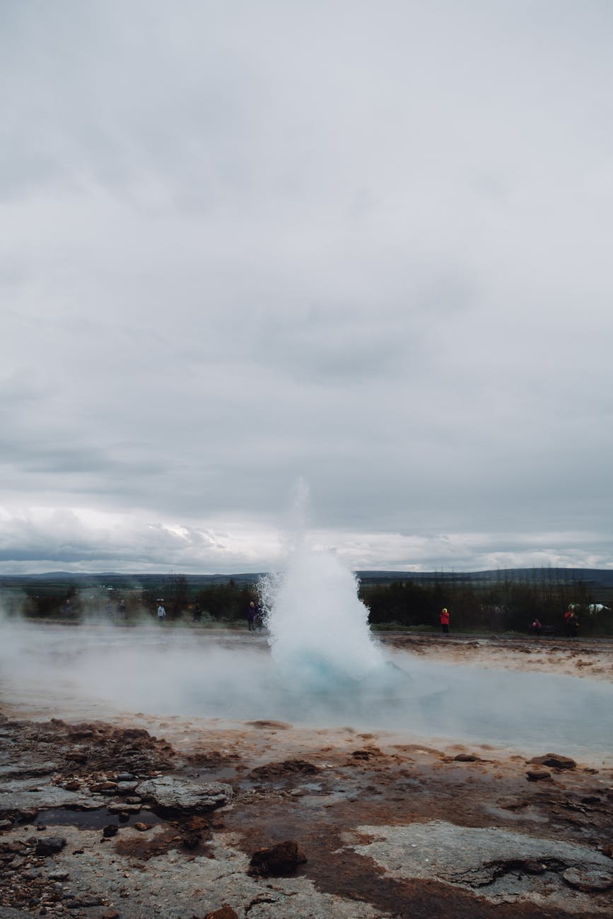 Geothermal geyser erupting steam high into the air