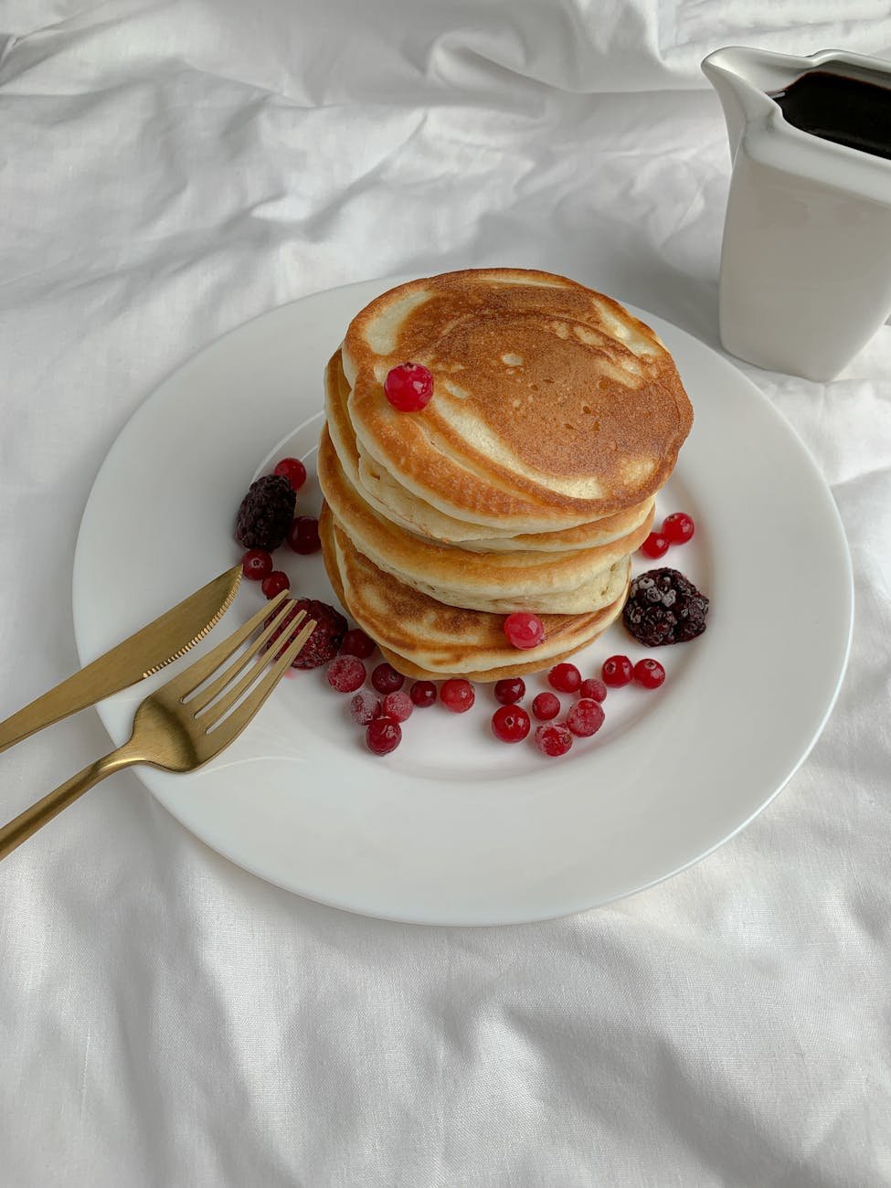 Stack of pancakes with berries on a brunch plate