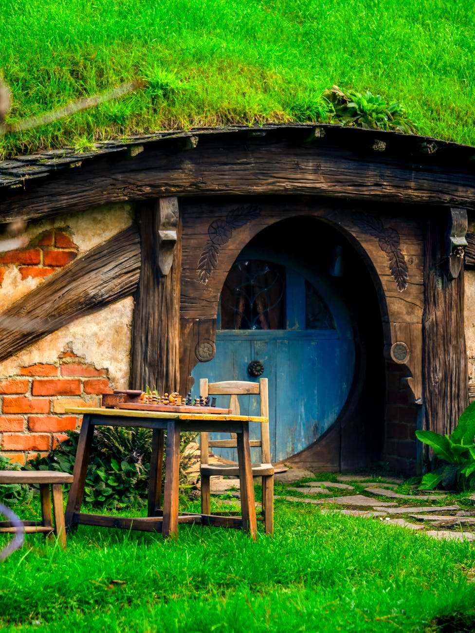 Multiple hobbit holes on a green hillside