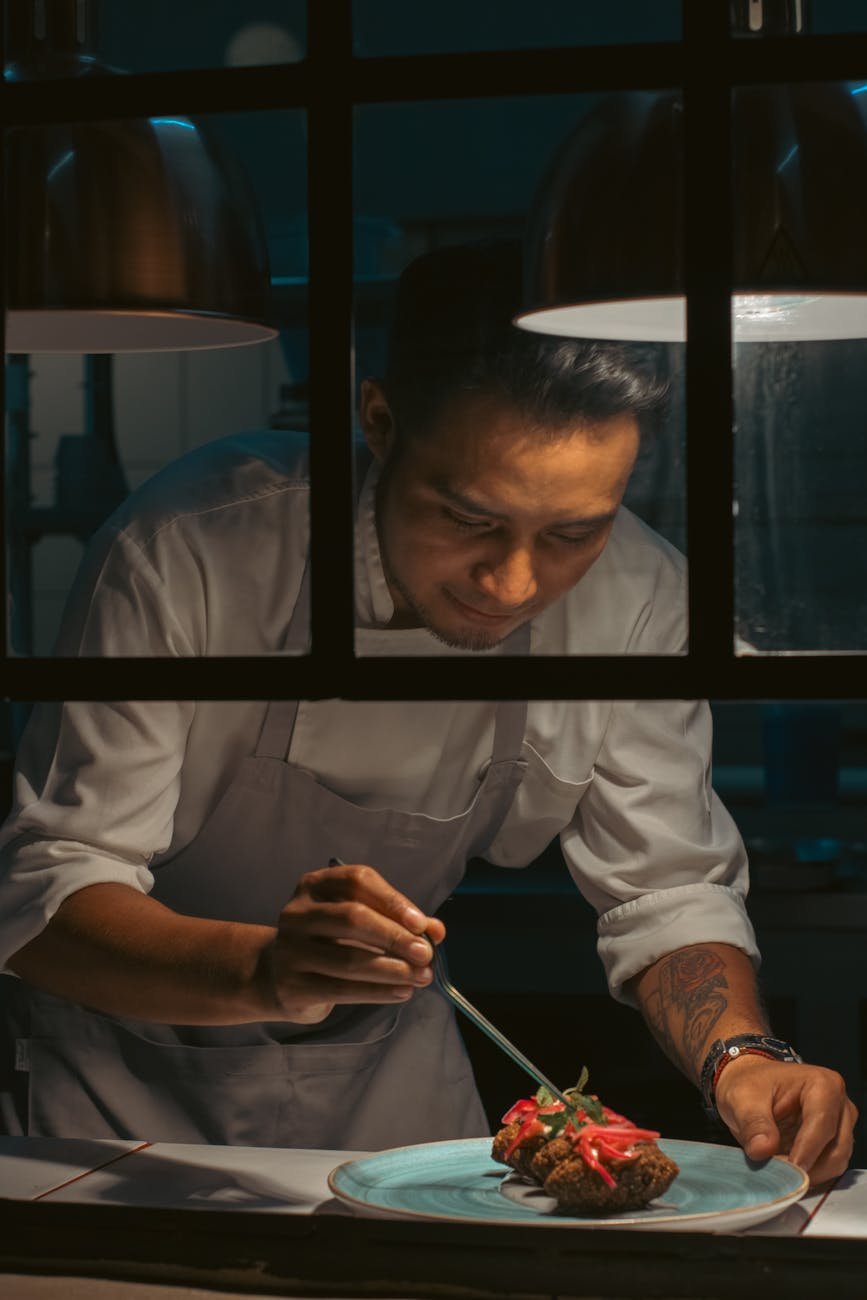Chef plating dish in fine dining open kitchen