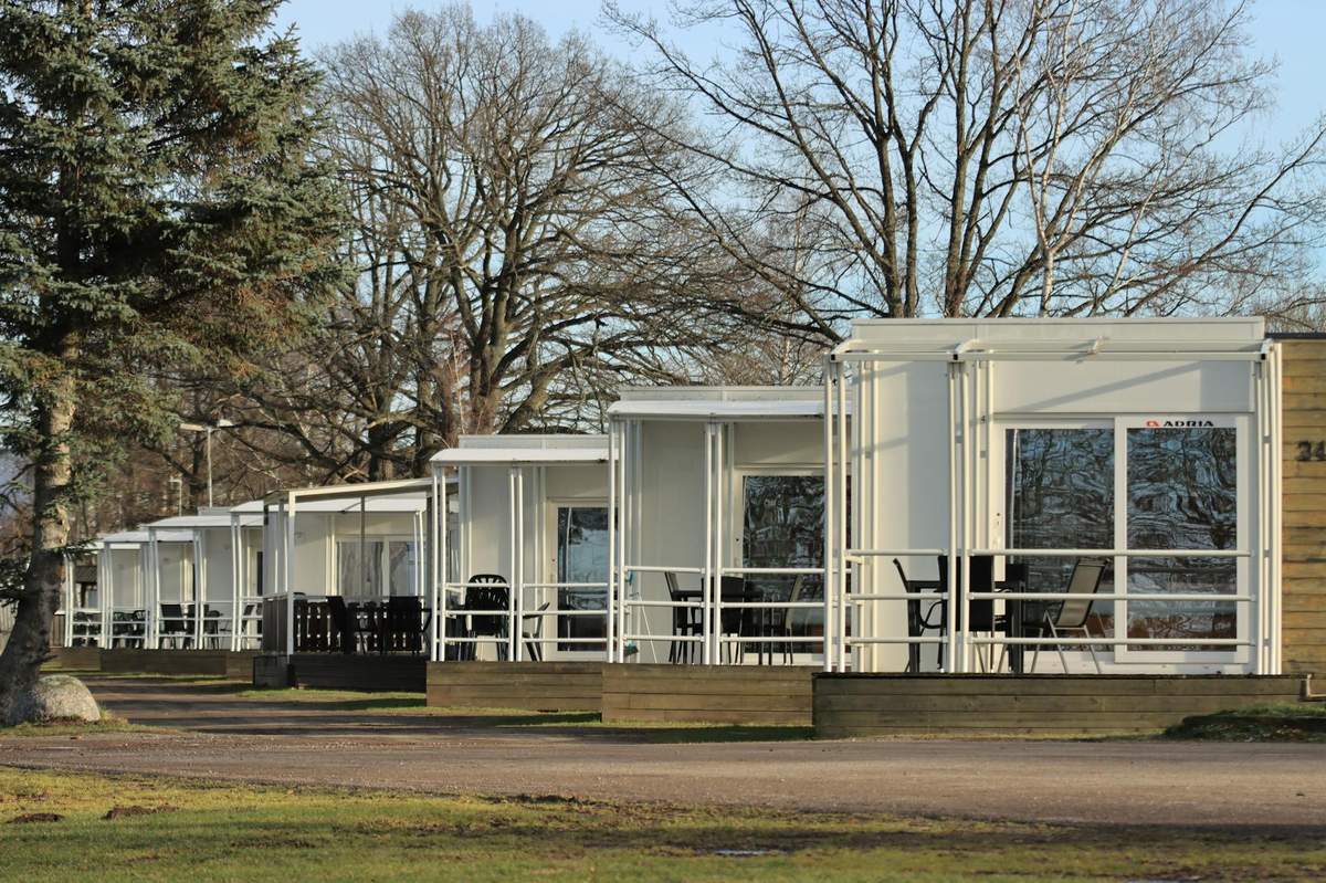 A row of modern white cabins with covered terraces