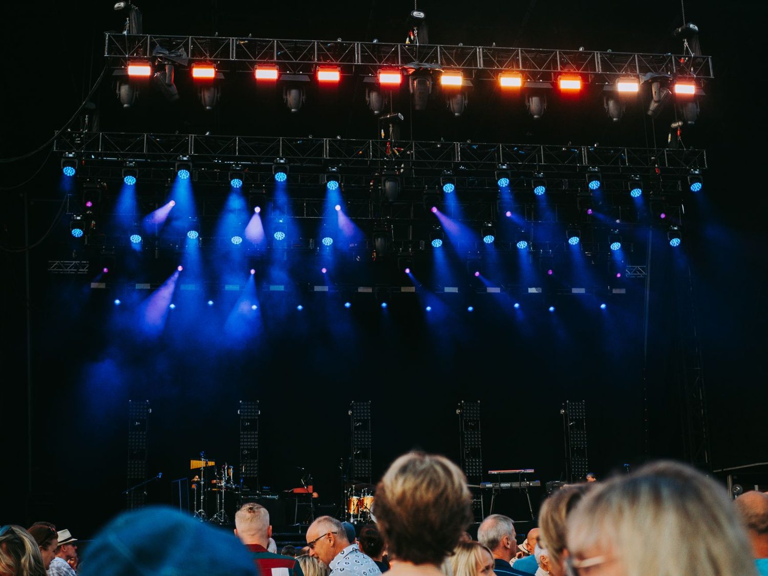 A live music crowd watching a lit stage at an Auckland concert