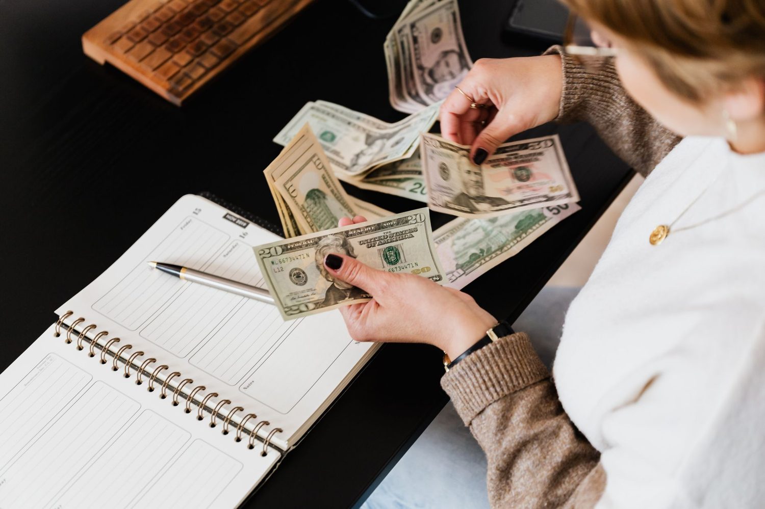 Planning an Auckland travel cost budget with New Zealand dollars and a notebook