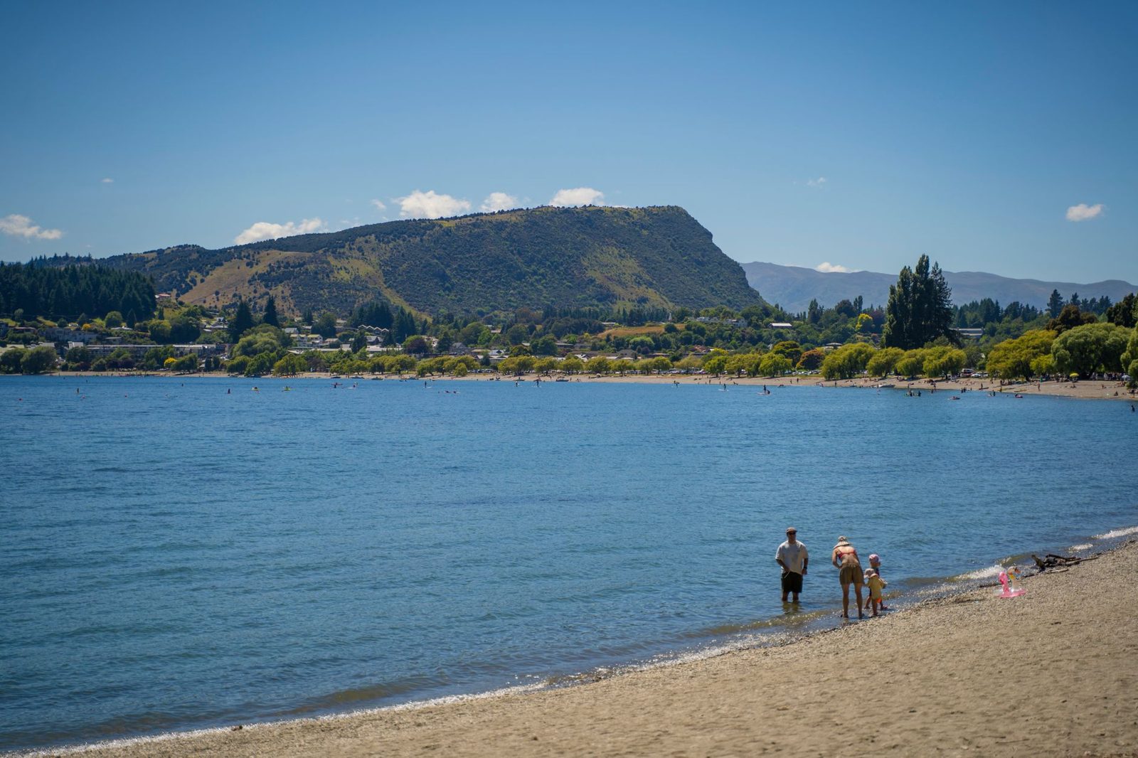 Family visiting Auckland with kids on a calm sandy beach