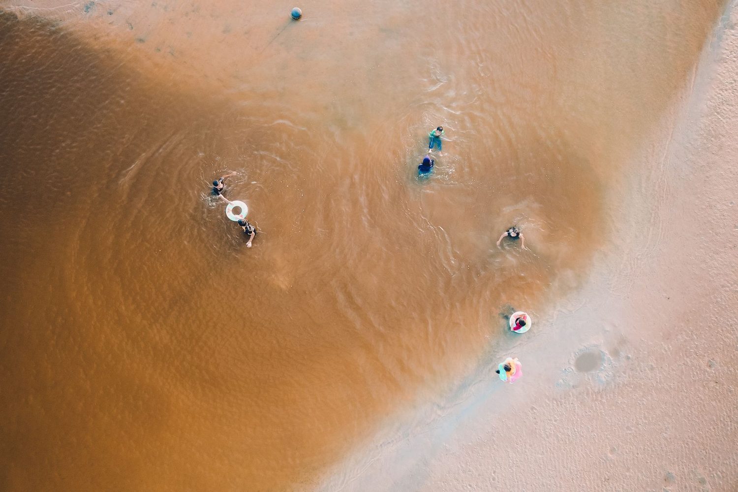 Families swimming in the calm, shallow water at Mission Bay beach