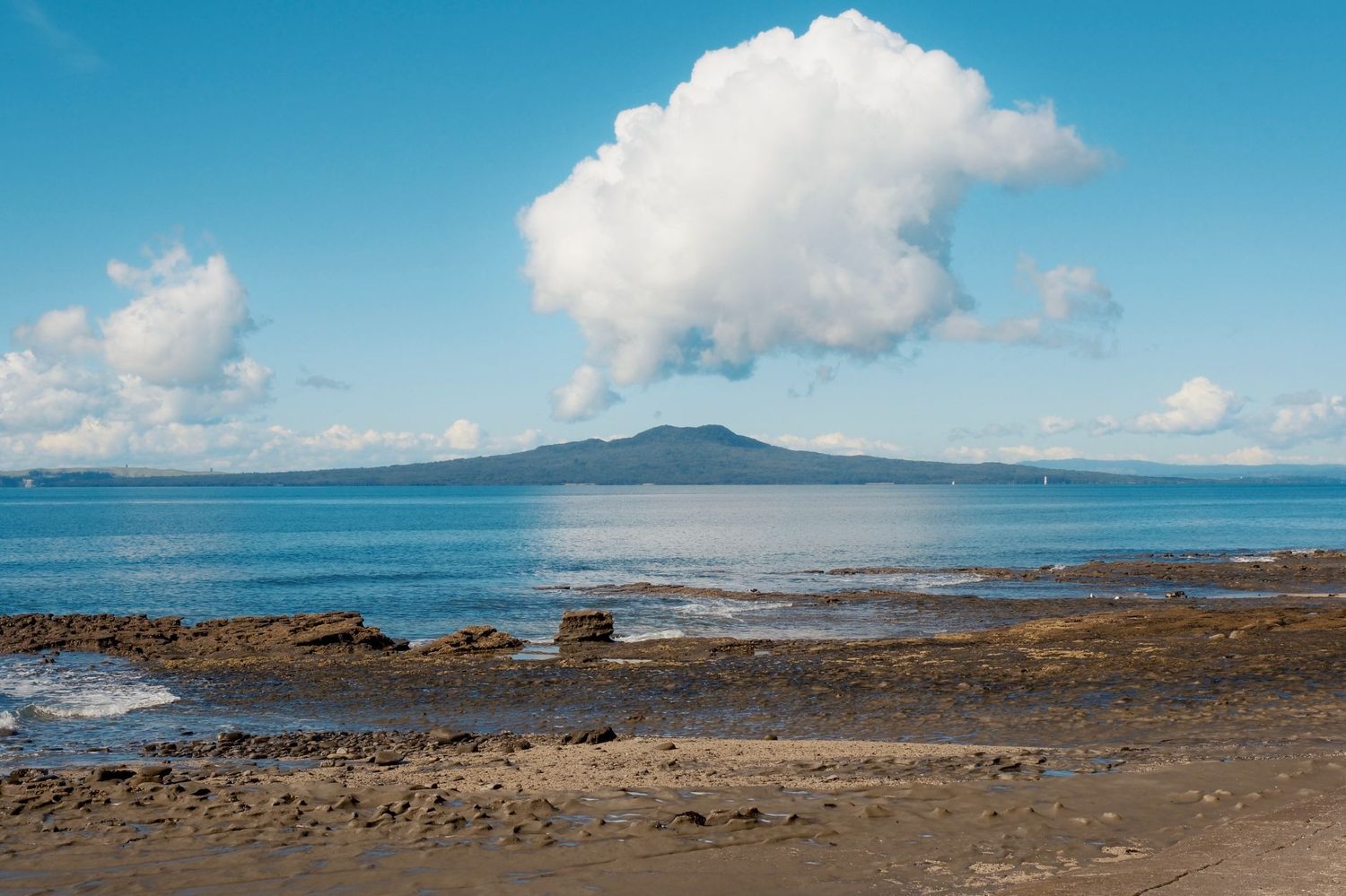 Takapuna Beach in Auckland with calm water and Rangitoto on the horizon
