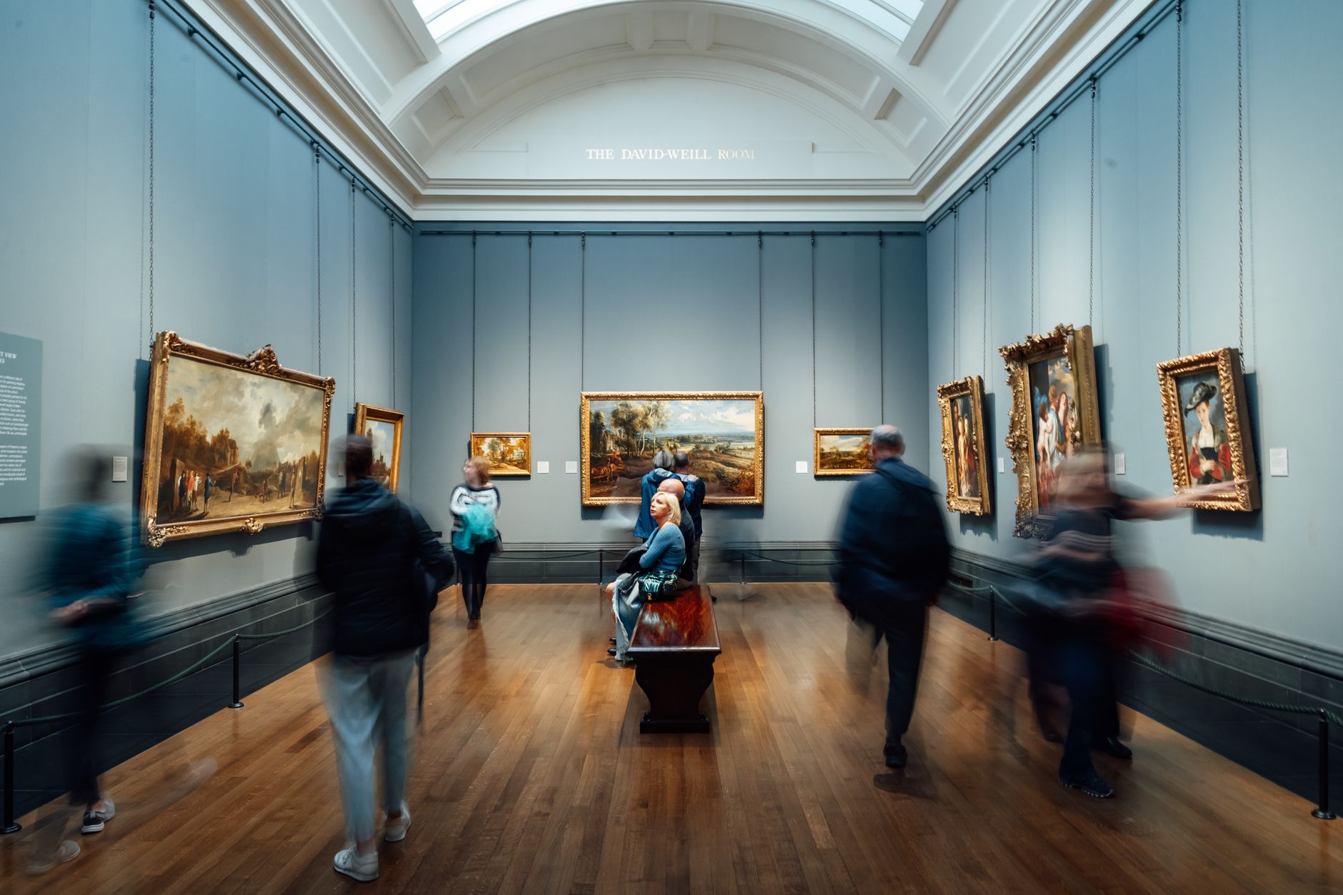 Visitors viewing paintings inside an Auckland art gallery