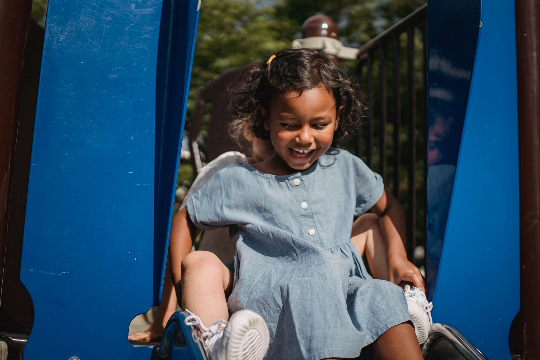 A toddler playing on a playground slide in an Auckland park