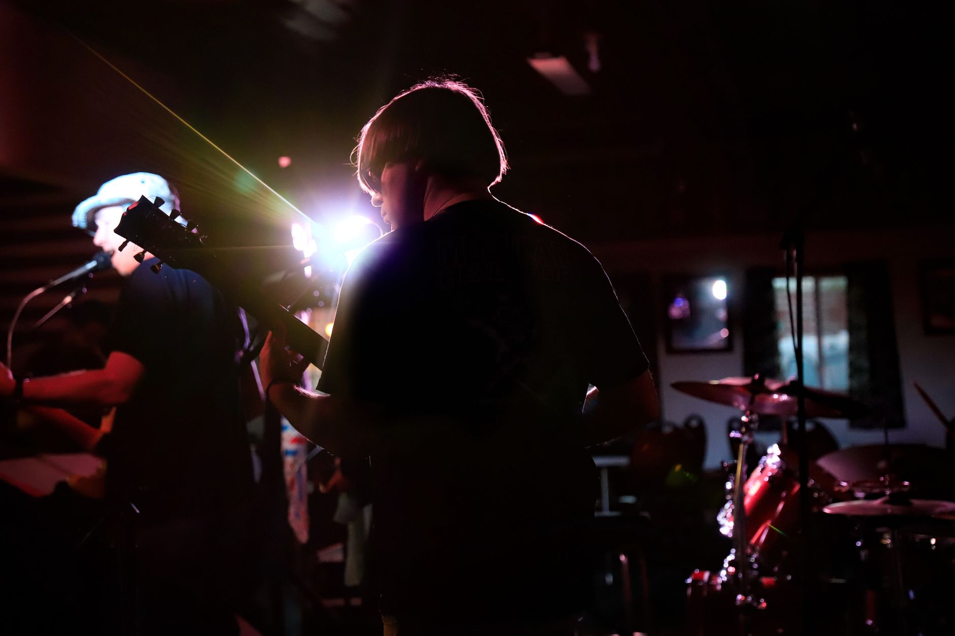 A band performing live in a small dimly lit music venue.