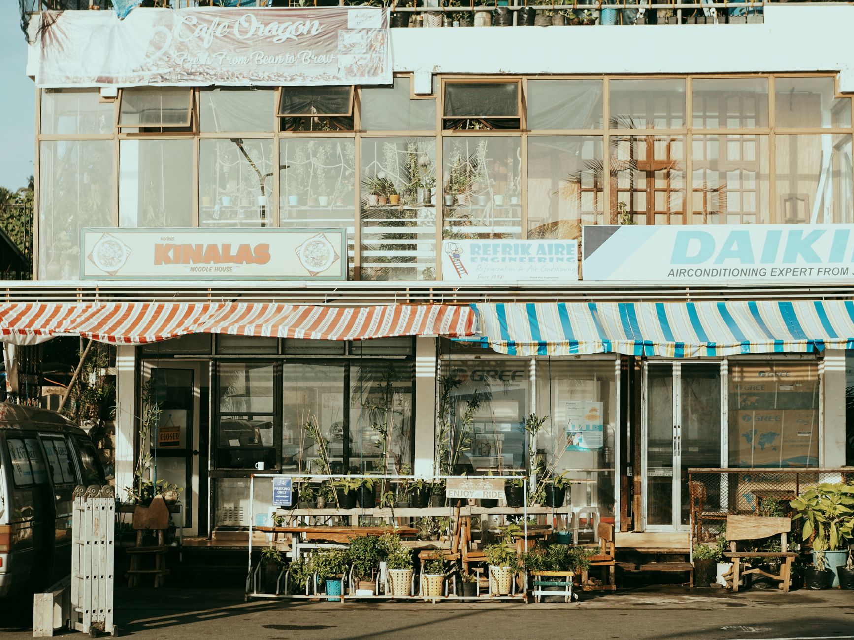 A suburban shopping strip with awnings and independent shopfronts