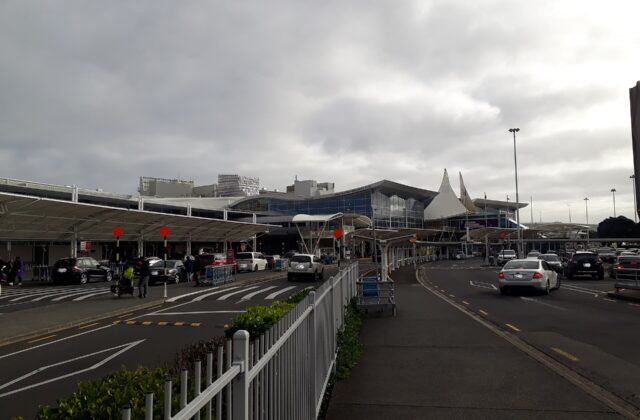 The kerbside frontage of Auckland Airport's international terminal, with covered walkways and traffic