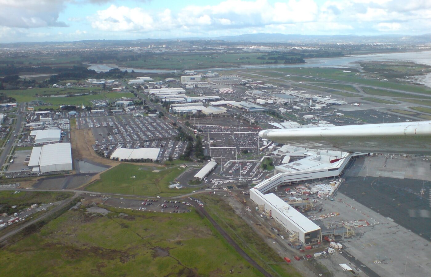 Aerial view over Auckland Airport showing the terminals, car parks and surrounding industrial precinct