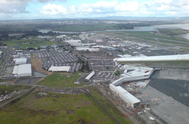 Aerial view over Auckland Airport showing the terminals, car parks and surrounding industrial precinct