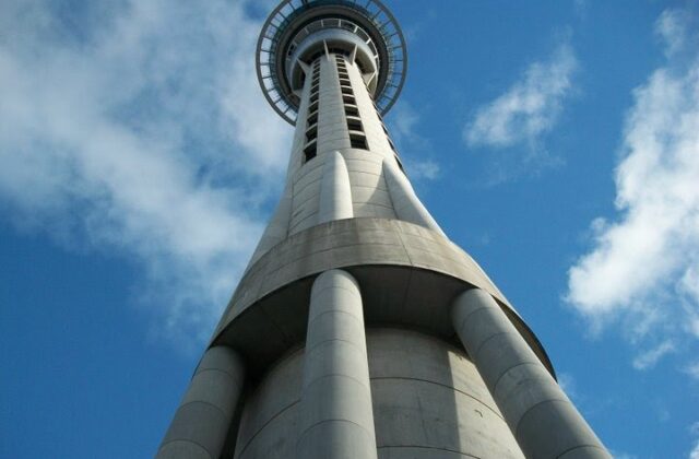 The Auckland Sky Tower seen looking straight up from its base against a blue sky