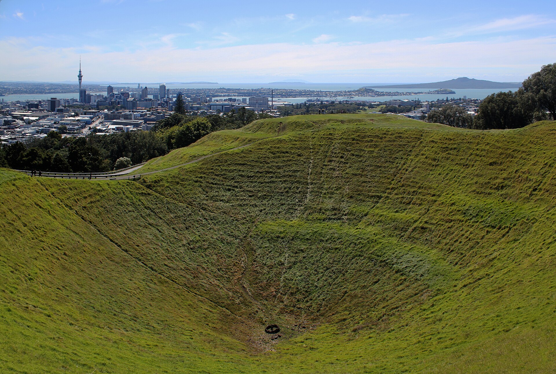 The grassed crater of Maungawhau / Mount Eden, with Auckland's city centre and Rangitoto beyond