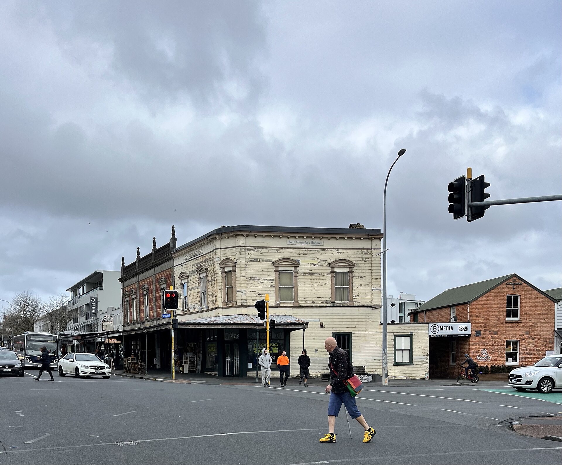 A corner of Ponsonby Road in Auckland with Victorian timber and brick shopfronts and a pedestrian crossing
